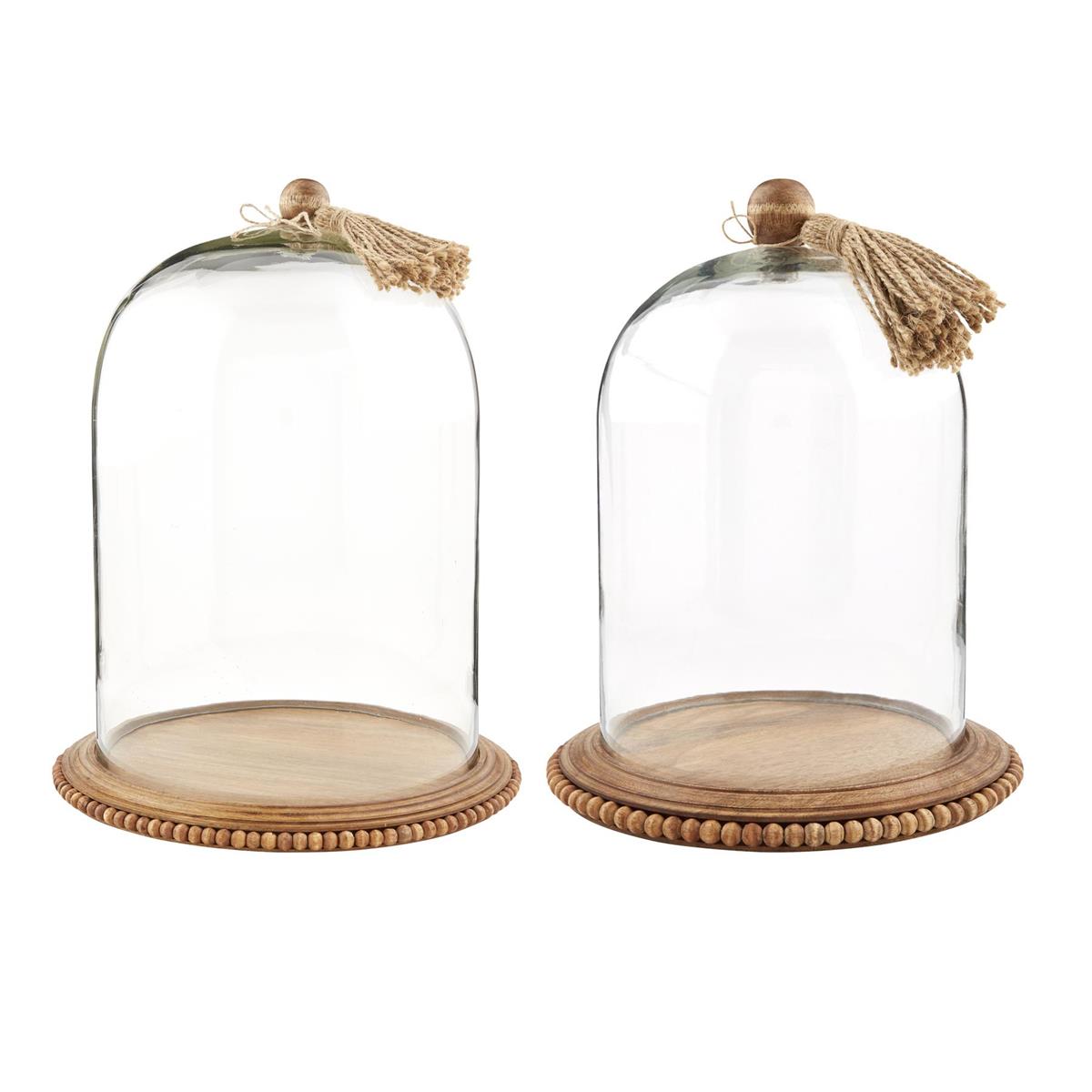 small and large glass cloche with tassels on a white background