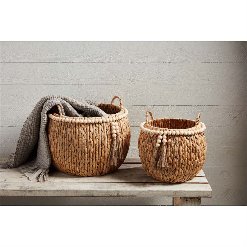 small and large hyacinth beaded baskets displayed on wooden bench with a gray blanket