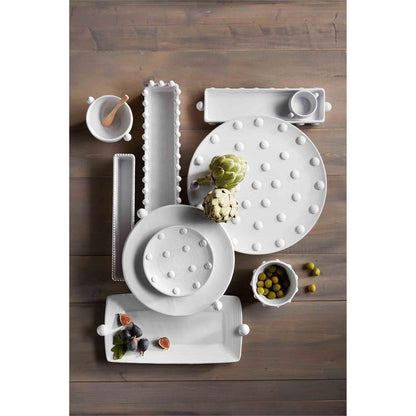 rectangle bead tray and dip set displayed with multiple other beaded serving pieces displayed with artichokes and green olives on a dark stained wooden plank table