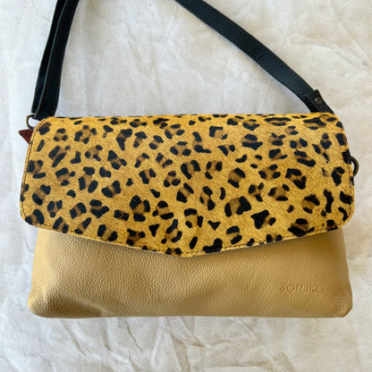 rounded khaki purse with brown and black cheetah print flap and black strap.