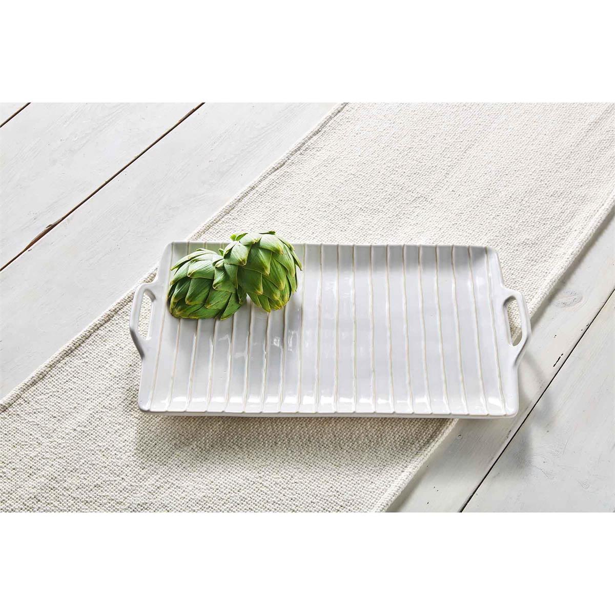 textured platter displayed with two artichokes on a white wood slat table