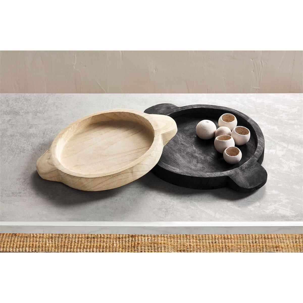 one black and one white round wood tray with handles on a light gray surface 