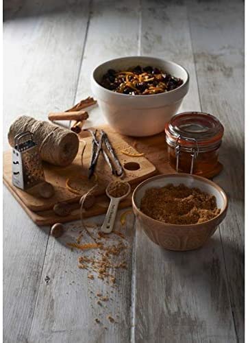 bowls, cutting board, spices, twine, and grater arranged on wooden tabletop.