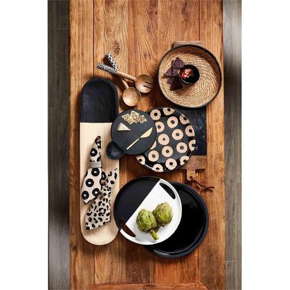 cheese board set displayed with multiple black and white, black and natural serving pieces on a rustic wood slat table 