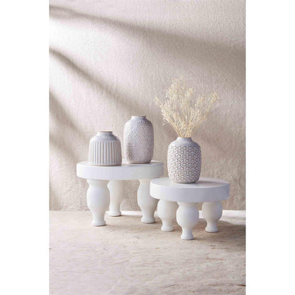 both sizes of white risers displayed with small textured vases and dried flowers