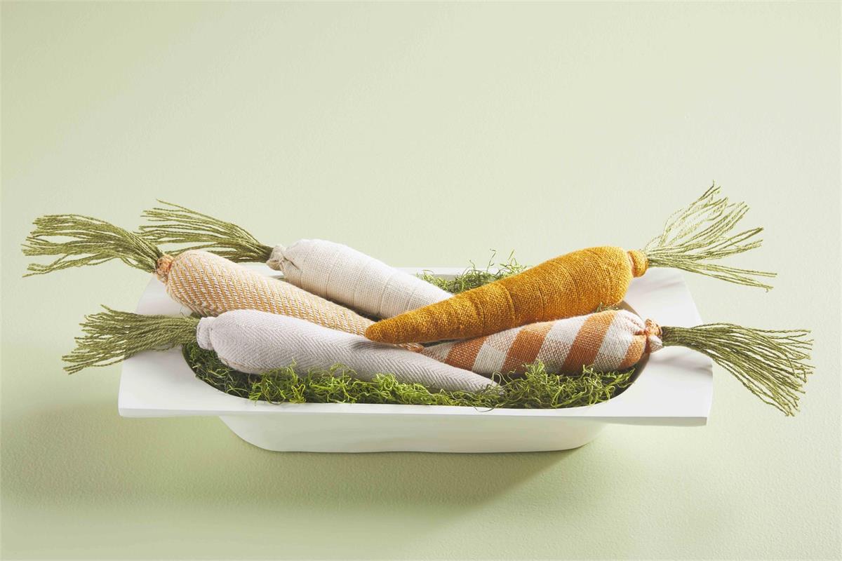 multiple decor carrots displayed in a dough bowl filled with moss on a white background