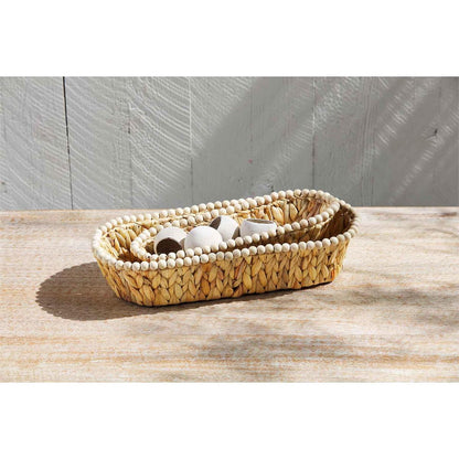 both sizes of hyacinth beaded bread baskets displayed on a wooden surface filled with white napkin rings