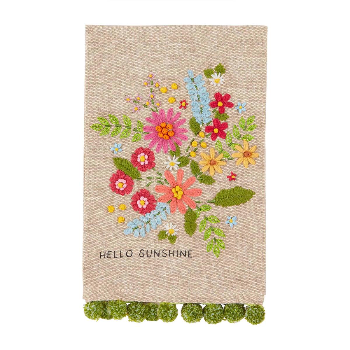 hello sunshine floral embroidered towel is tan with a green pom trim against a white background