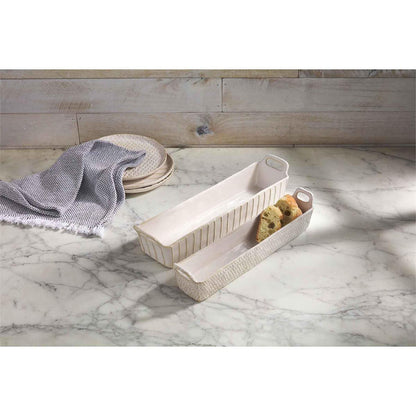 small and large cracker dish displayed with a set of stacked plate towel on a white marble countertop