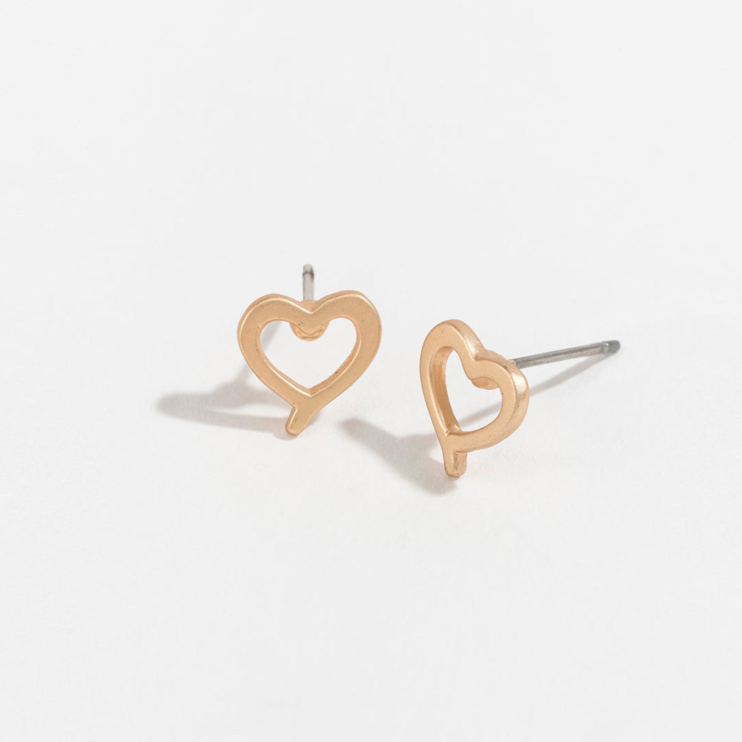 gold heart stud earrings on a white background
