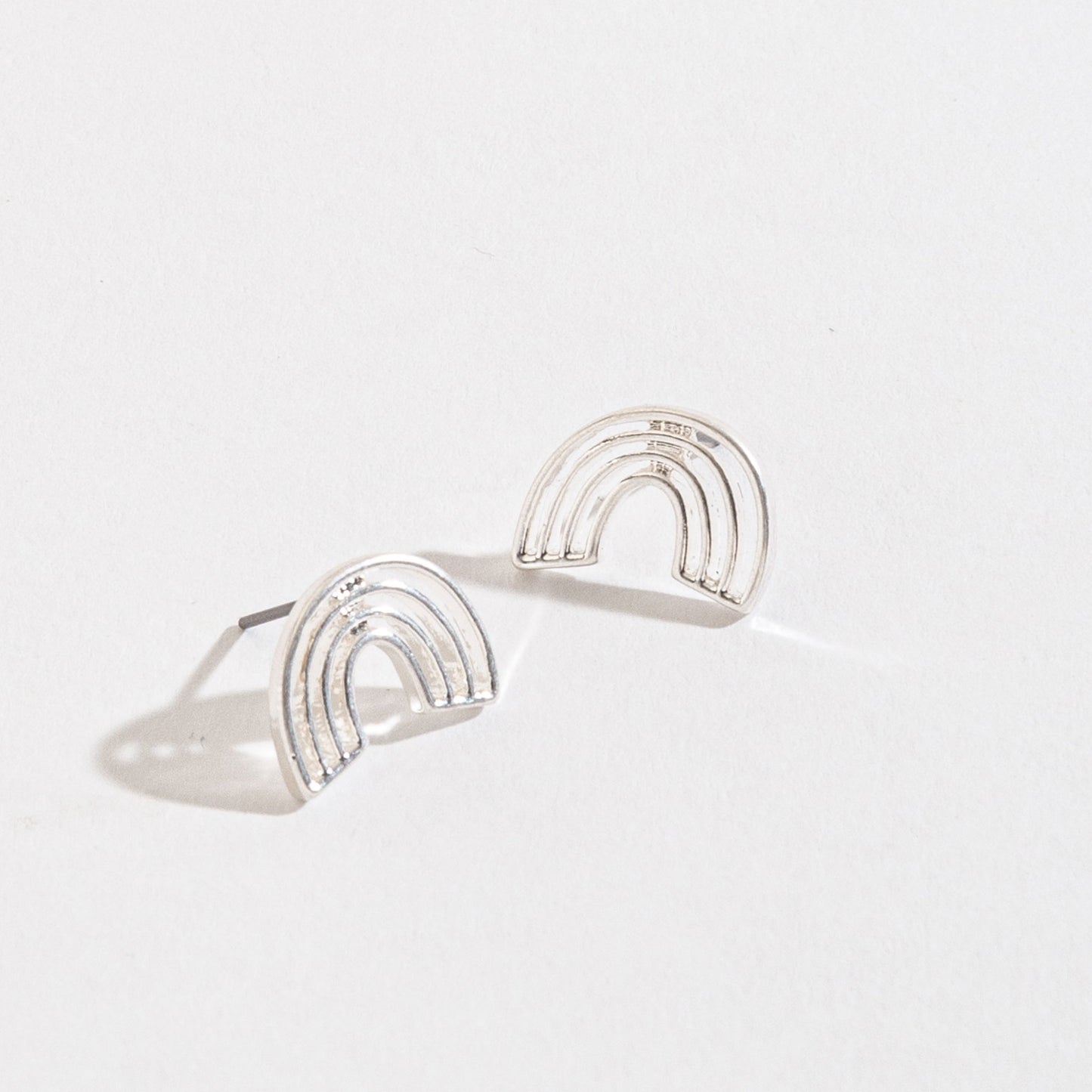 silver rainbow stud earrings on a white background