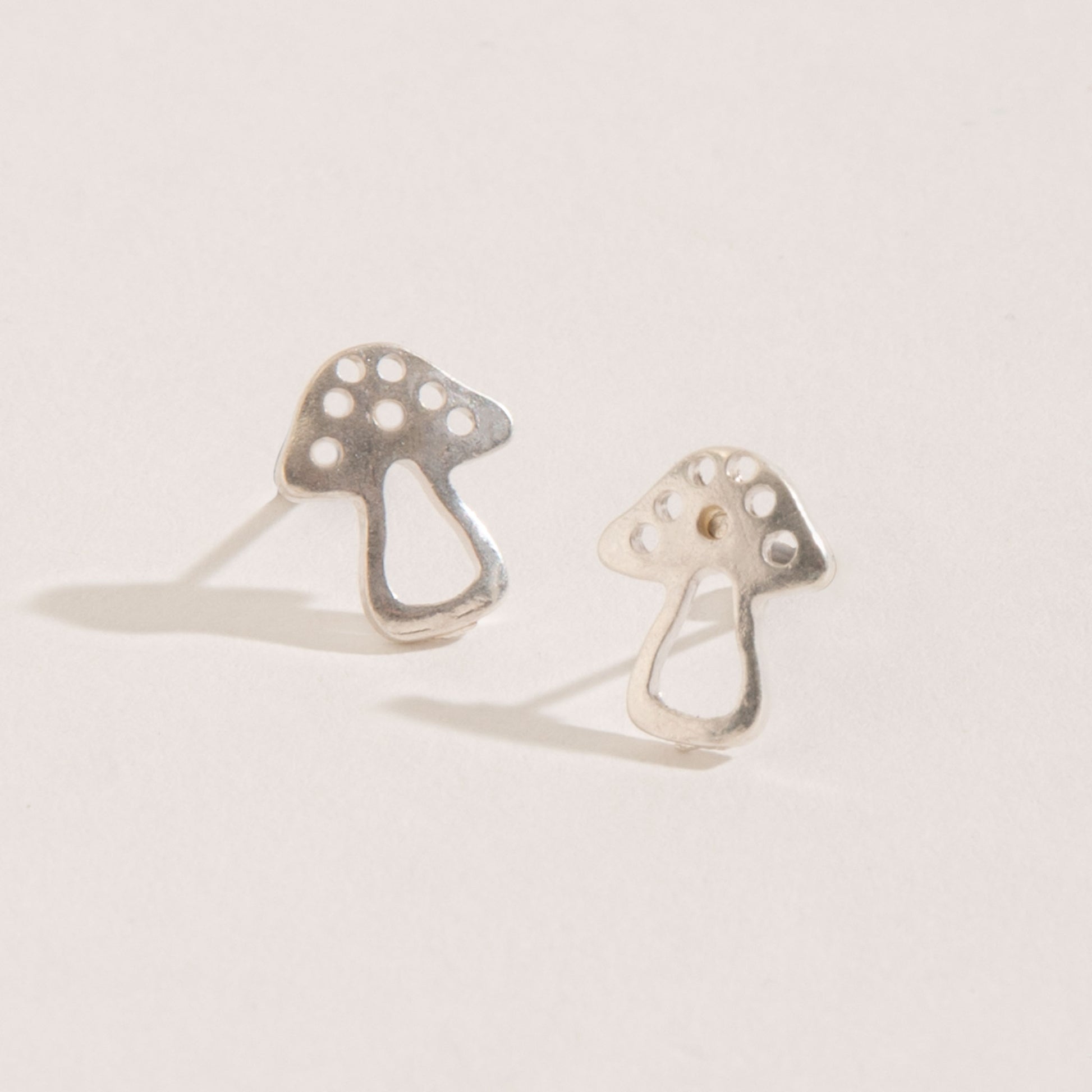 silver mushroom stud earrings on a white background