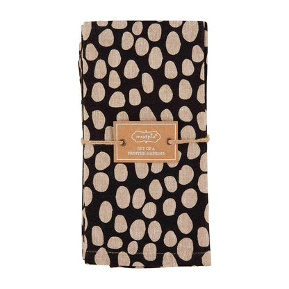 napkin is black with tan dots folded and tied with twine on a white background