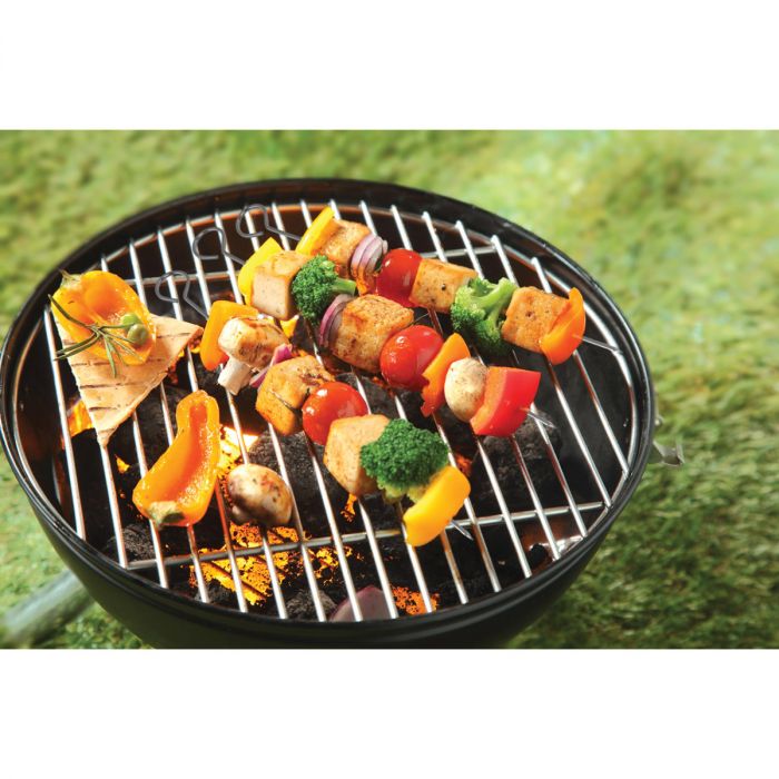 the non stick skewers displayed on a grill sitting in the grass