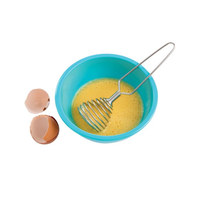 the french coil whisk displayed in a bowl of whisked eggs next to cracked egg shells on a white background