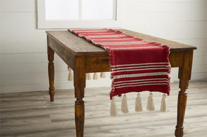 wooden table with red striped runner on it.