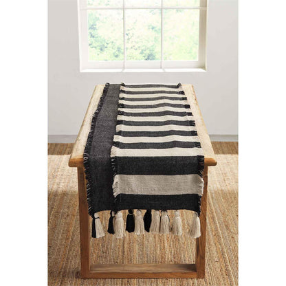 ponchaa table runners displayed on a light wood table in front of a window