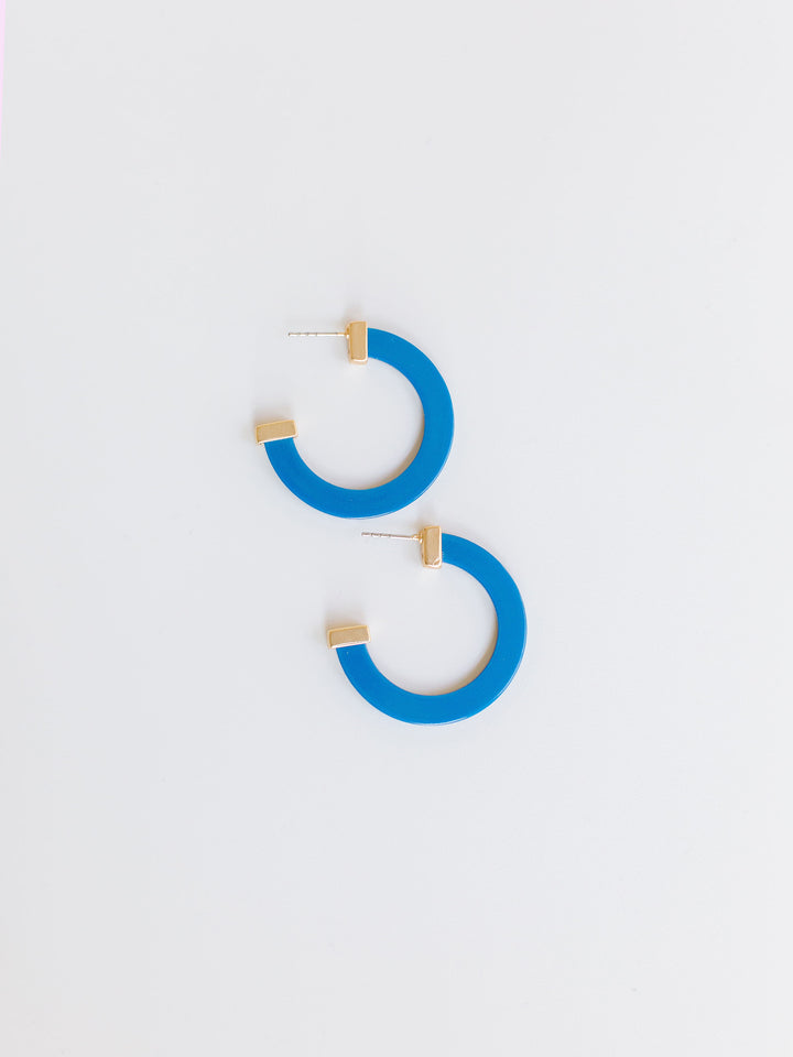 blue hoop earrings with gold ends on a white background.