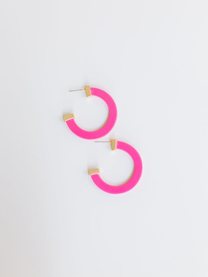 pink hoop earrings with gold ends on a white background.