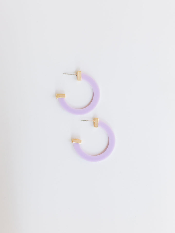 lilac hoop earrings with gold ends on a white background.