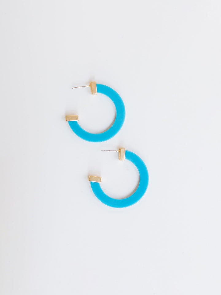 blue hoop earrings with gold ends on a white background.