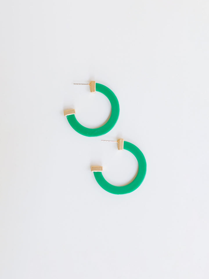 green hoop earrings with gold ends on a white background.