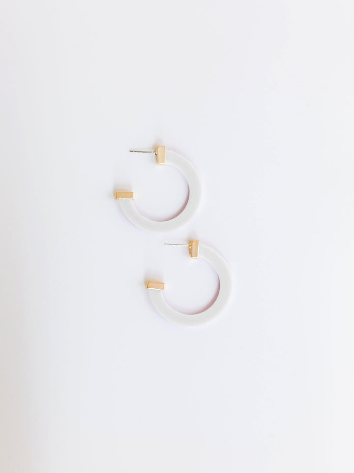 white hoop earrings with gold ends on a white background.