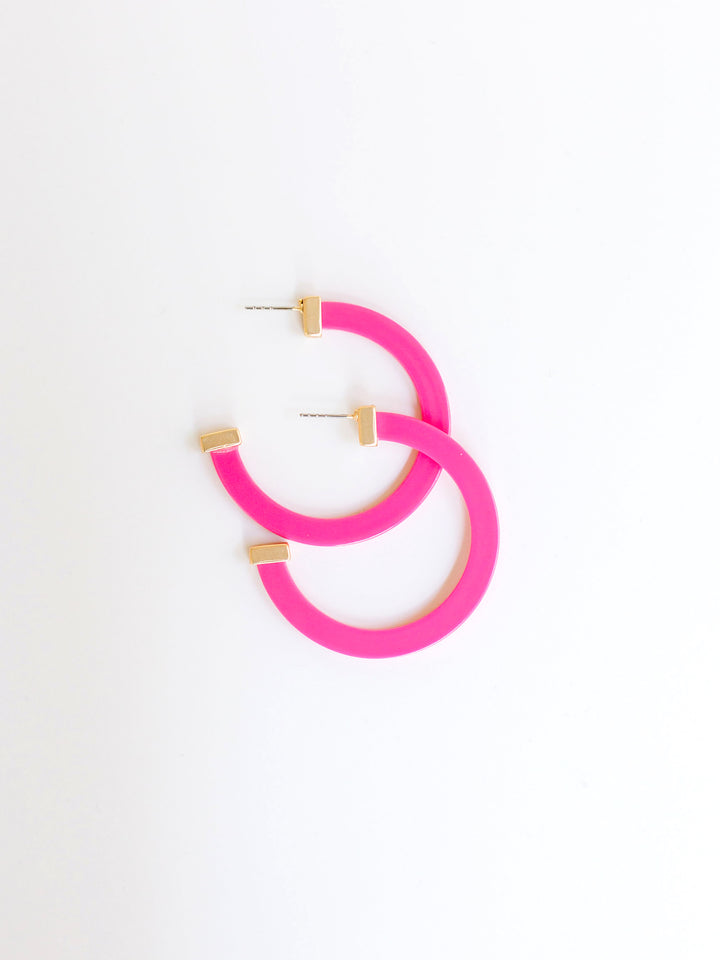 pink hoop earrings with gold ends on a white background.