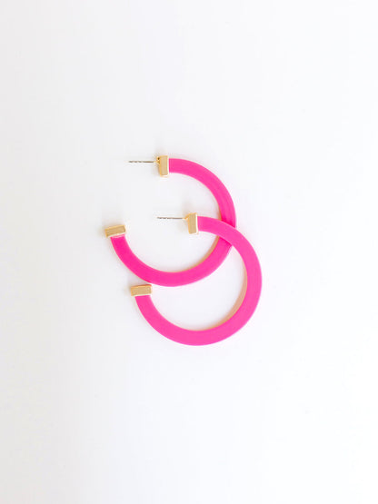 pink hoop earrings with gold ends on a white background.