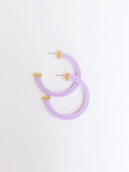 lilac hoop earrings with gold ends on a white background.