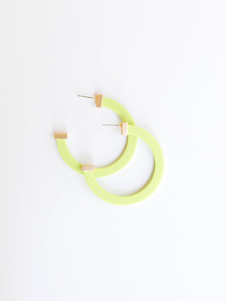 lime hoop earrings with gold ends on a white background.