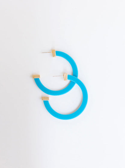 blue hoop earrings with gold ends on a white background.