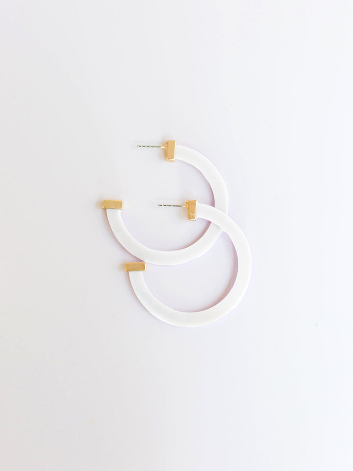 white hoop earrings with gold ends on a white background.