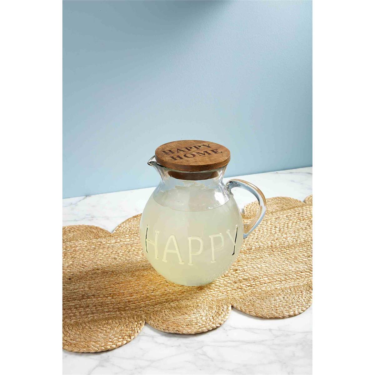 happy pitcher filled with lemonade and displayed on a braided grass table runner