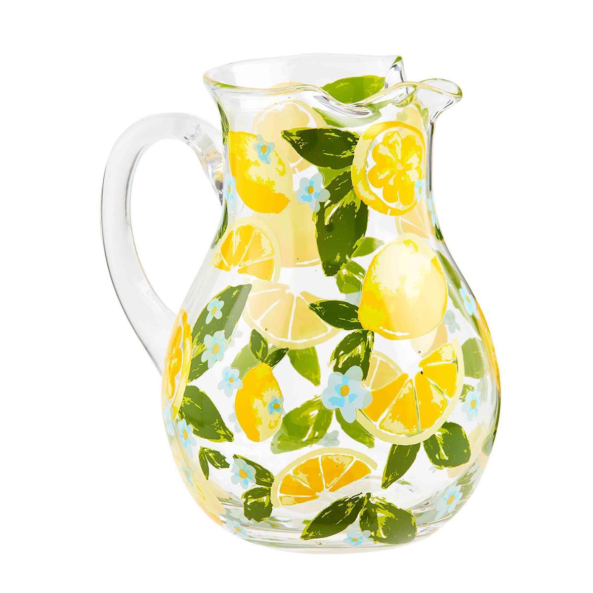 lemon pitcher is clear glass with lemons, leaves, and small blue flowers all over it on a white background