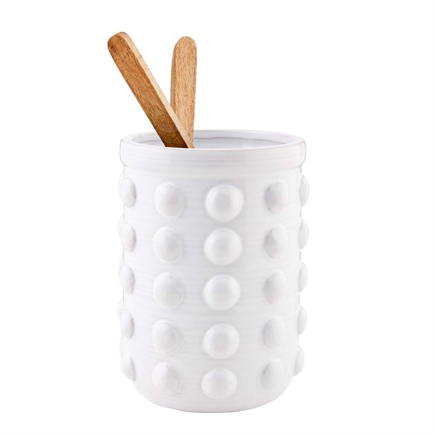 raised dot utensil crock with two wooden utensils on a white background