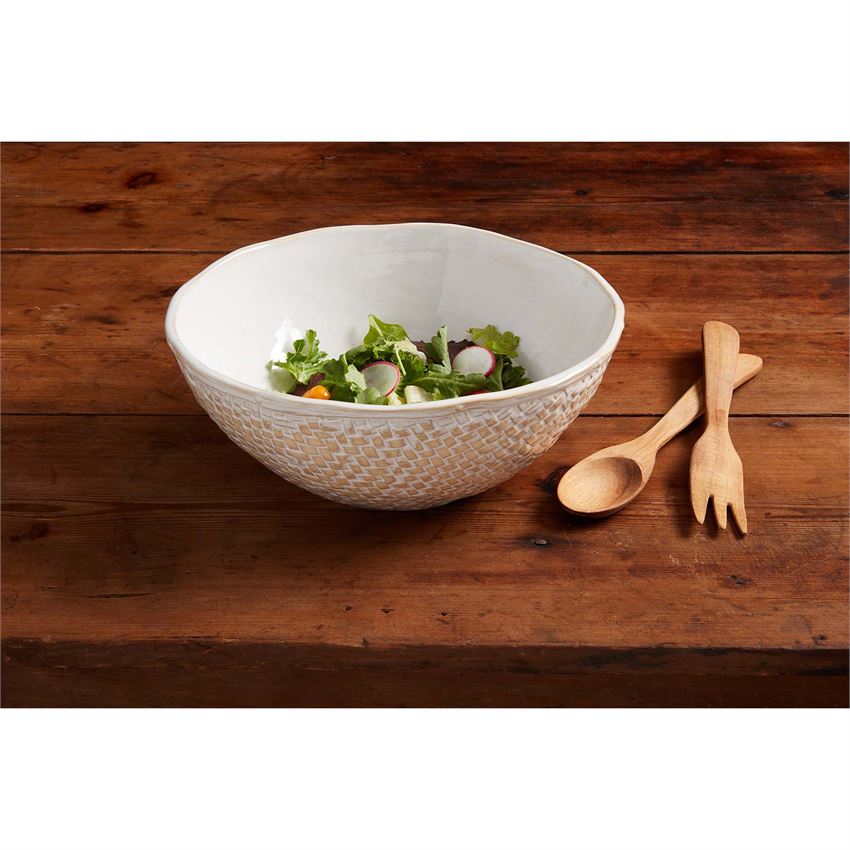 basket weave bowl set with salad on a wooden table against a white background