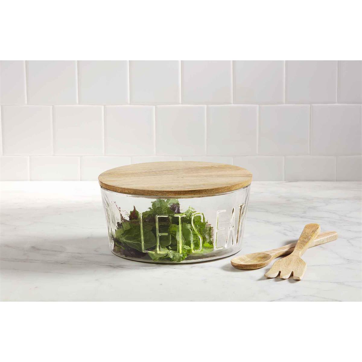 let's eat glass bowl set displayed with lettuce inside on a white countertop