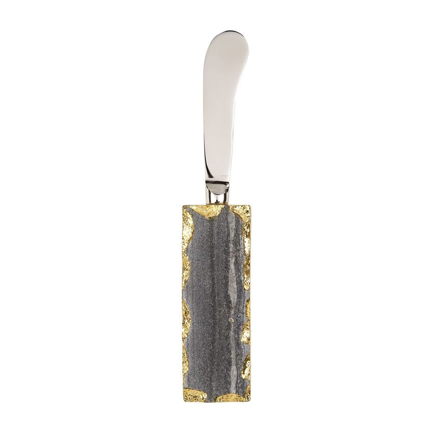 stainless steel spreader with grey marble and gold rimmed handle.