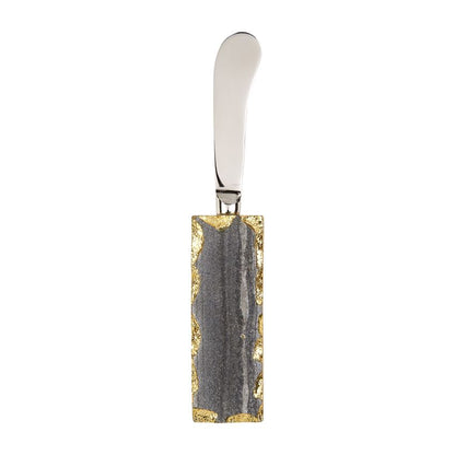 stainless steel spreader with grey marble and gold rimmed handle.