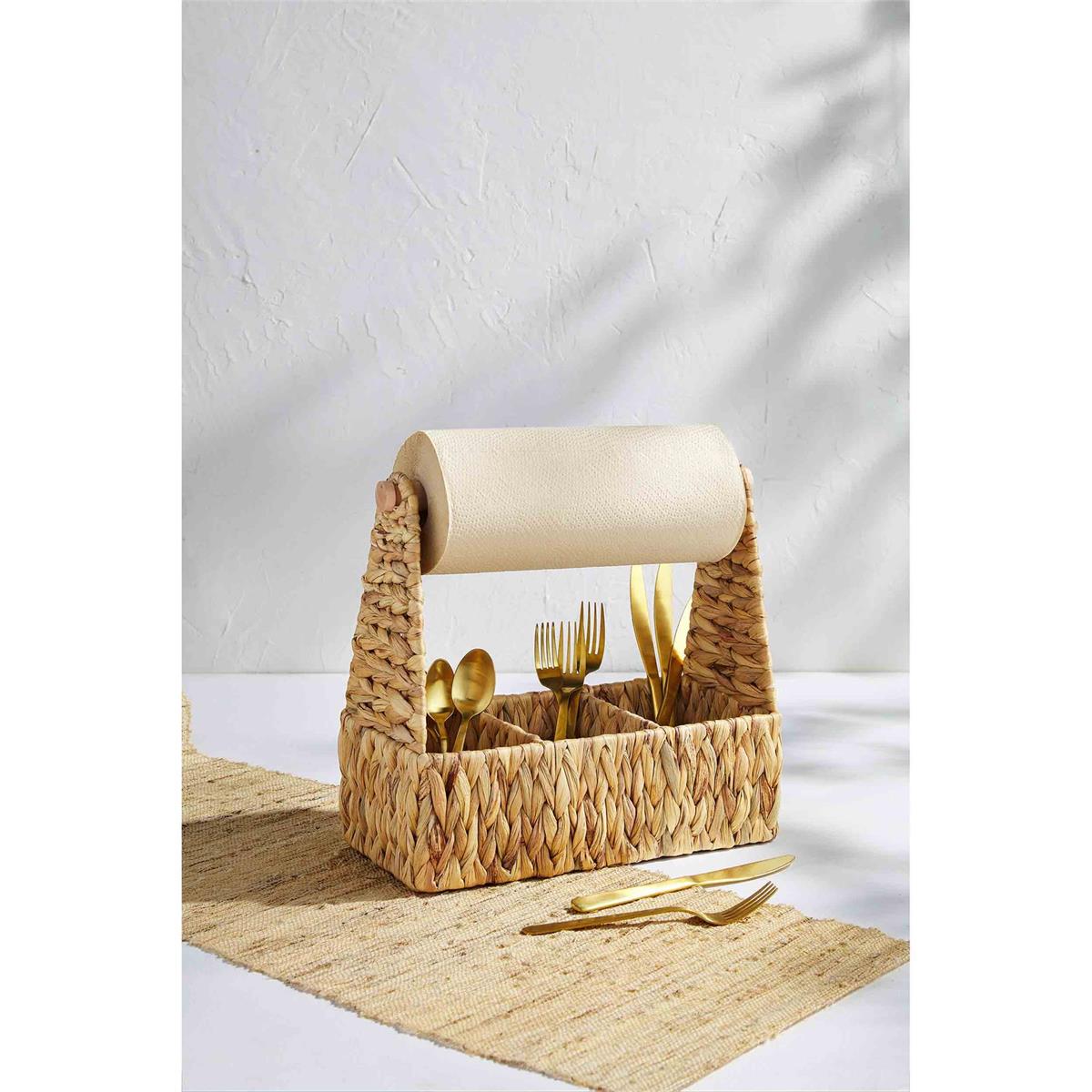 woven utensil and towel caddy displayed with gold flatware inside on a white surface next to a tan table runner