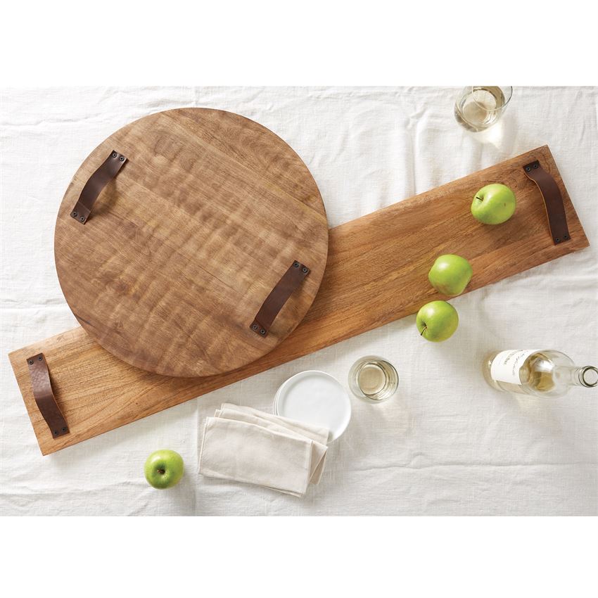 oversized rectangle wood serving board displayed with a round one, apples, bottle of wine, and napkins on a white tablecloth