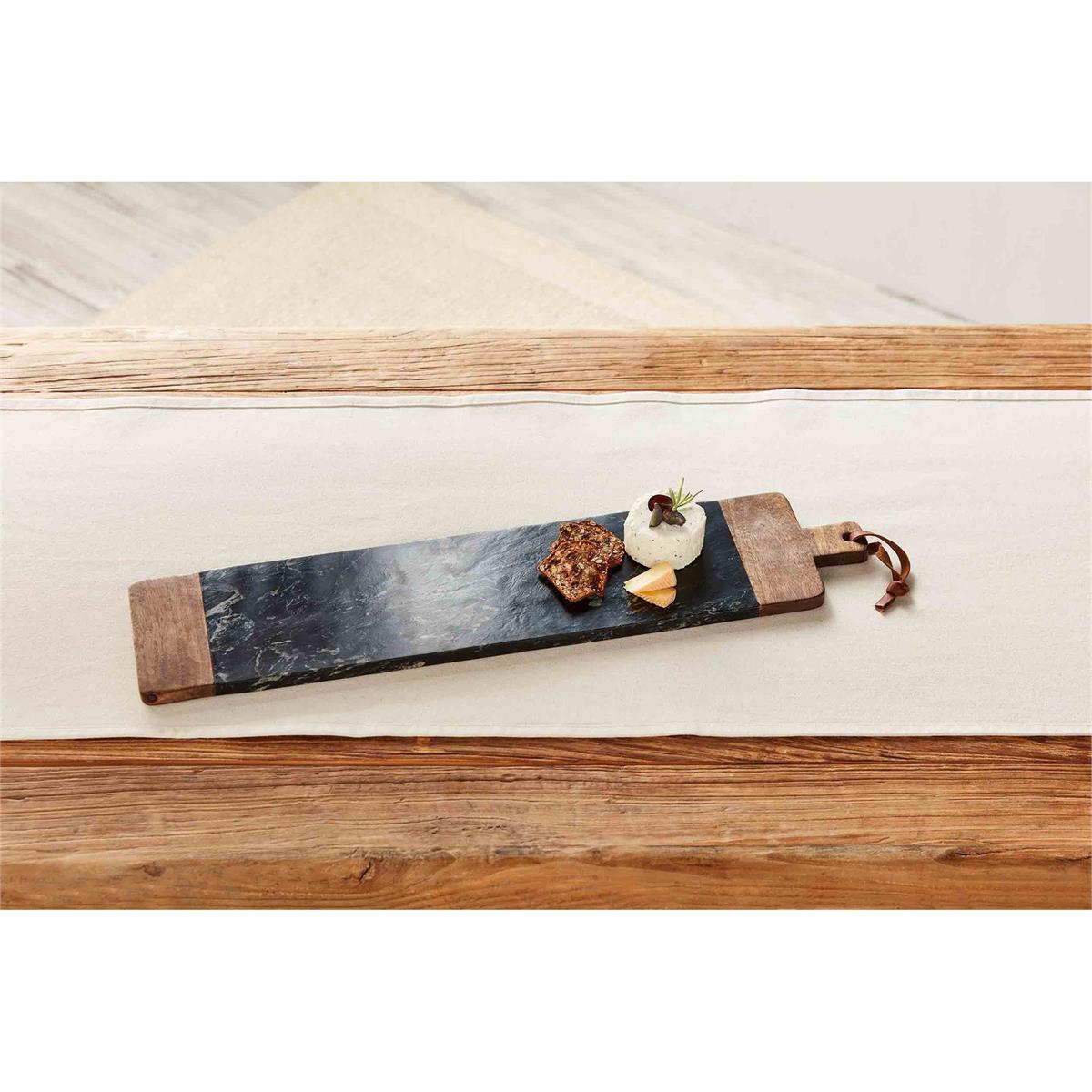 natural and black long board with three different cheeses displayed on a white table runner on a rustic wood table