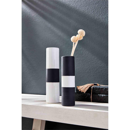 2 sizes of black and white vases on a white wooden shelf, smaller vase has dried botanicals in it.