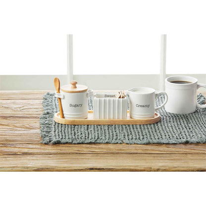 circa cream and sugar set displayed on a gray placemat on a light wood slat table