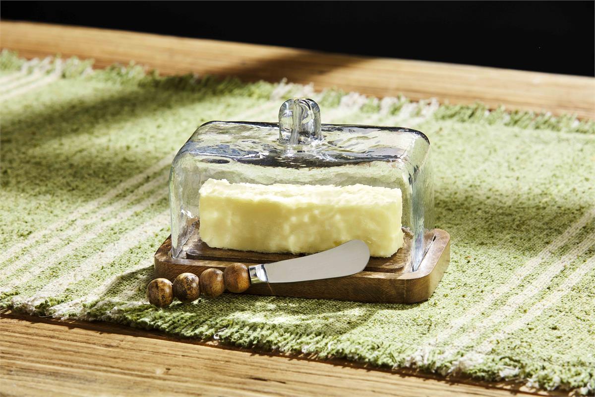 beaded butter dish and spreader displayed on a green and white table runner on a table