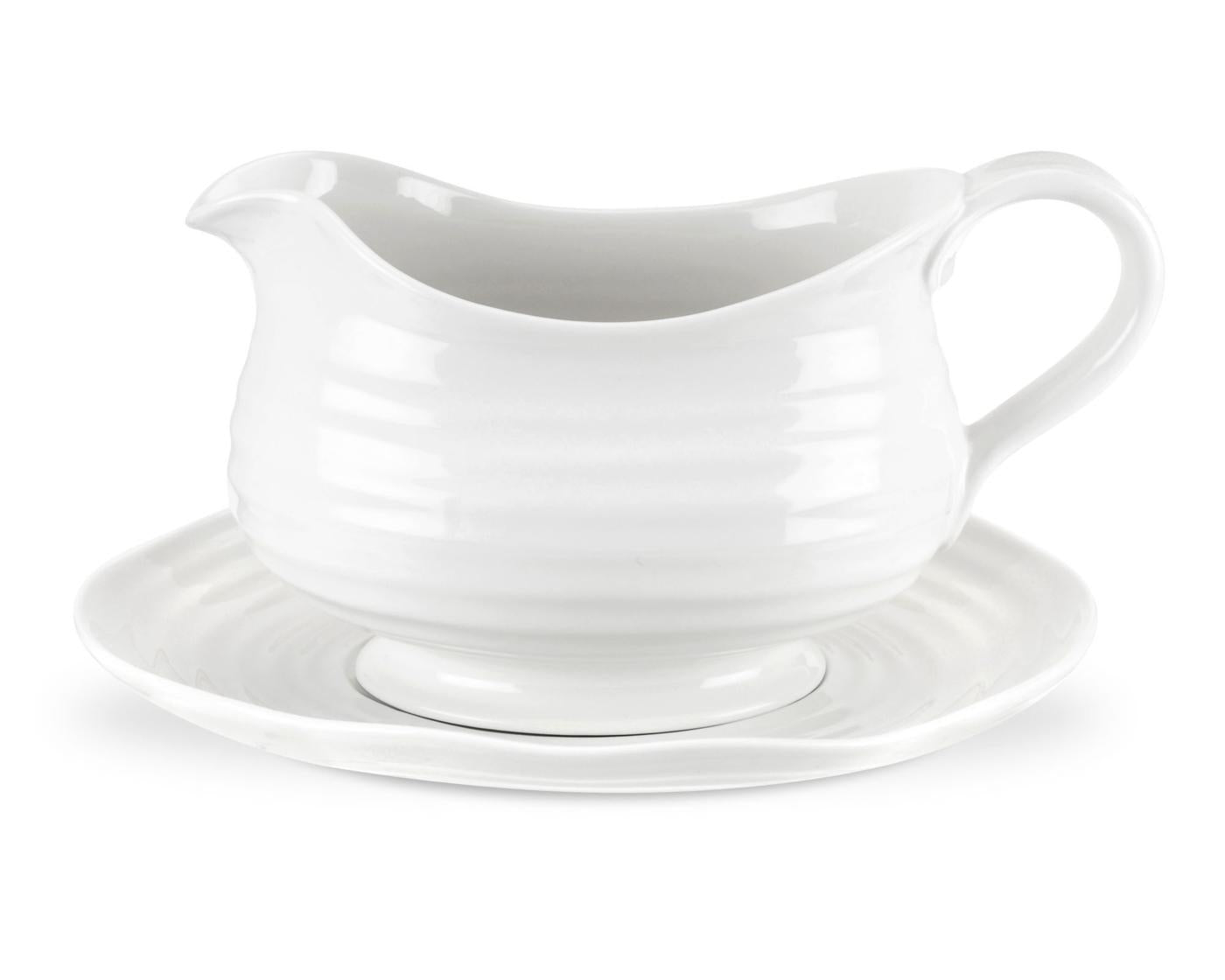 side view of gravy boat sitting on saucer.