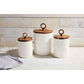 all three sizes of the textured stoneware canisters displayed on a counter surface against a whitewashed wood slat wall