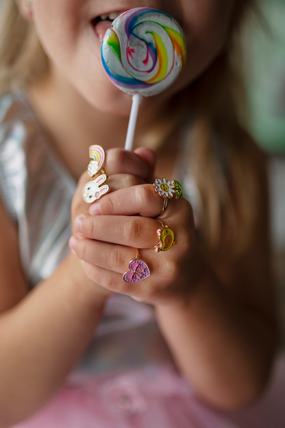 a little girl wearing the spring ring set while holding a sucker