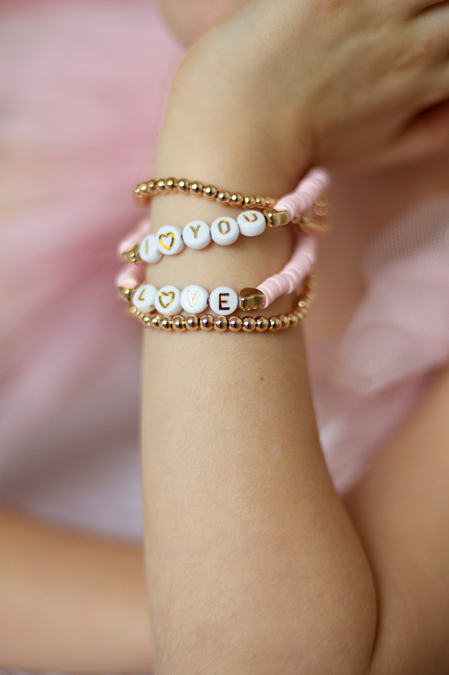 a young girl wearing the pink love bracelets on her wrist 